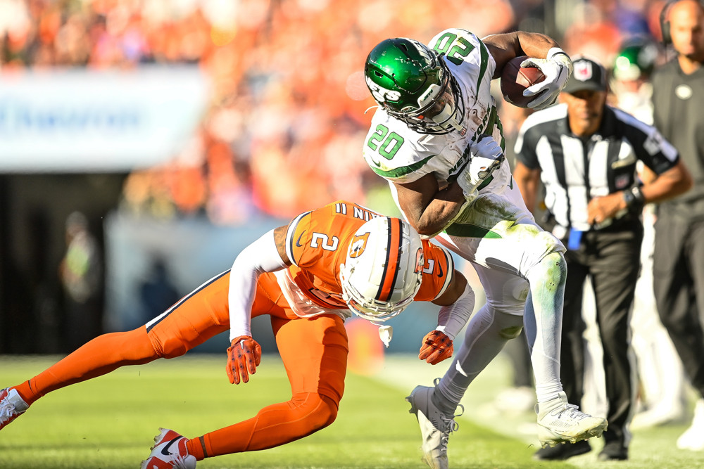 New York Jets running back Breece Hall (20) is tackled by Denver Broncos cornerback Pat Surtain II (2) in the third quarter during a game between the New York Jets and the Denver Broncos at Empower Field at Mile High on October 8, 2023 in Denver, Colorado.