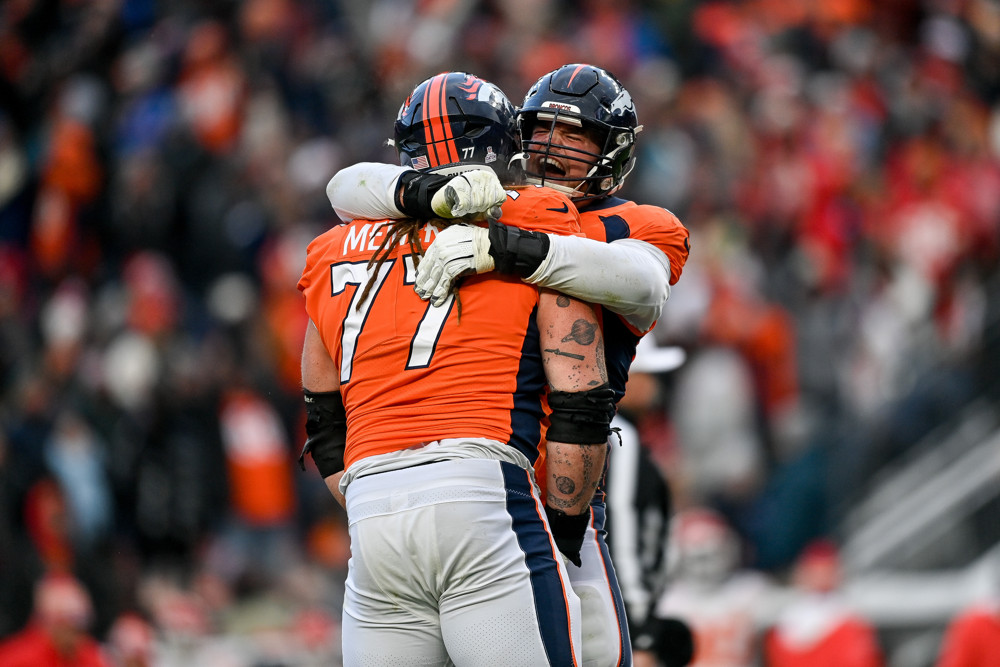 Denver Broncos offensive tackle Mike McGlinchey (69) and guard Quinn Meinerz (77) celebrate after a Denver Broncos touchdown in the fourth quarter against the Kansas City Chiefs at Empower Field at Mile High on October 29, 2023 in Denver, Colorado.