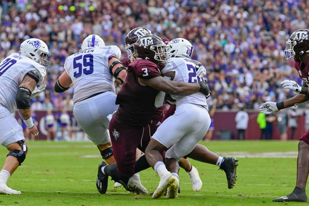 Texas A&M Aggies defensive lineman McKinnley Jackson (3) wraps up Abilene Christian Wildcats running back Jordan Vaughn (26) during first half action during the football game between the Abilene Christian Wildcats and Texas A&M Aggies at Kyle Field on November 18, 2023  in College Station, Texas.