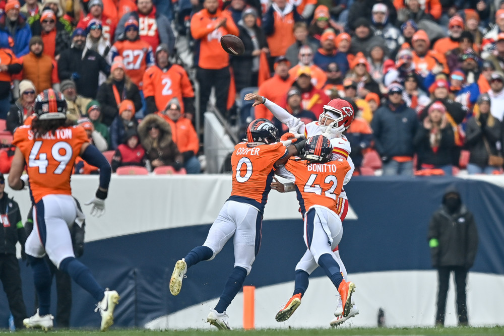 Kansas City Chiefs quarterback Patrick Mahomes (15) is pressured by Denver Broncos linebacker Jonathon Cooper (0) and linebacker Nik Bonitto (42) in the first half at Empower Field at Mile High on October 29, 2023 in Denver, Colorado.