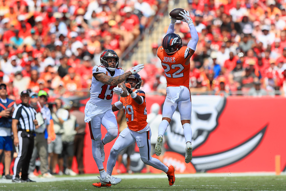 Tampa Bay Buccaneers Wide Receiver Mike Evans (13) is defended by Denver Broncos Defensive Back Ja'Quan McMillian (29) as Denver Broncos Safety Brandon Jones (22) goes up high to make the interception during the game between the Denver Broncos and the Tampa Bay Buccaneers on September 22, 2024 at Raymond James Stadium in Tampa, Florida.