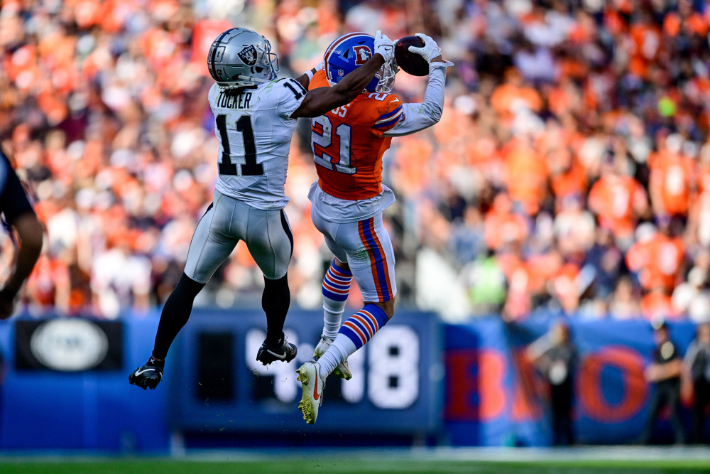 Denver Broncos cornerback Riley Moss (21) intercepts a pass intended for Las Vegas Raiders wide receiver Tre Tucker (11) in the fourth quarter during a game between the Las Vegas Raiders and the Denver Broncos at Empower Field at Mile High on October 6, 2024 in Denver, Colorado.