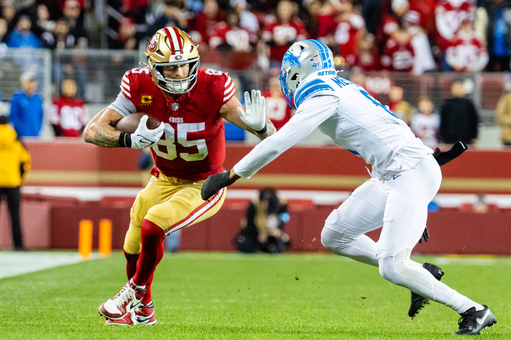 San Francisco 49ers tight end George Kittle (85) runs with the ball against Detroit Lions safety Ifeatu Melifonwu (6) during a NFL game on December 30, 2024 at Levi's Stadium in Santa Clara, CA.