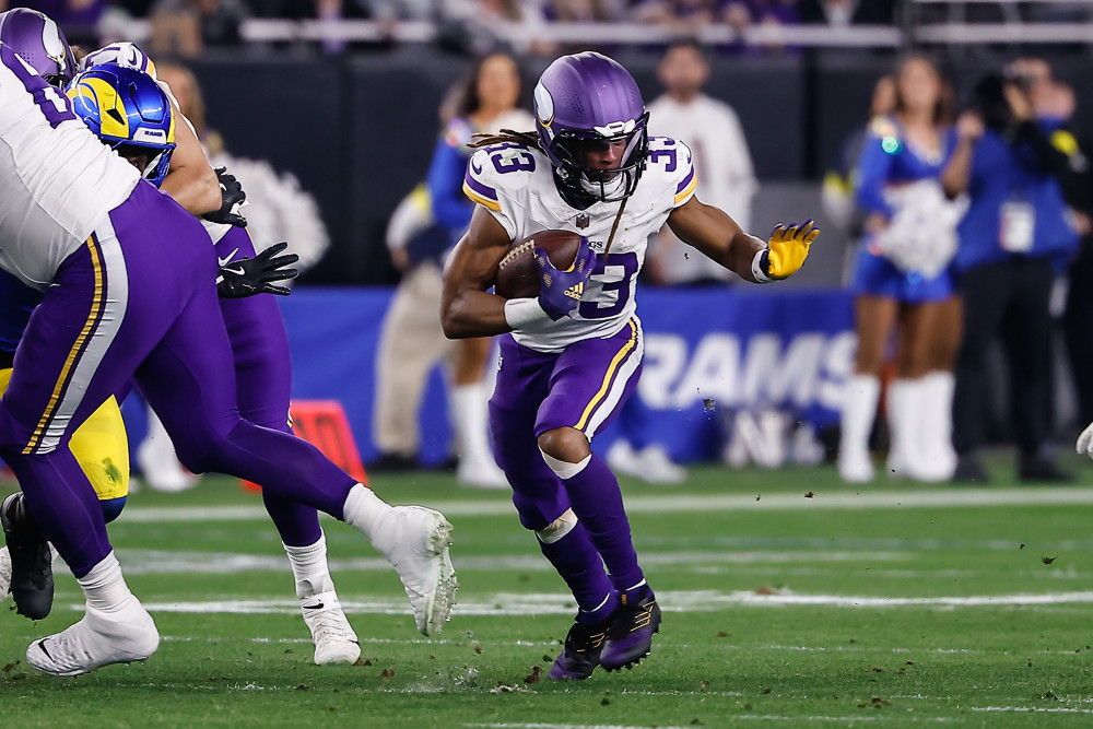 Minnesota Vikings running back Aaron Jones (33) runs the ball during the NFL Wild Card Playoff football game between the Minnesota Vikings and the Los Angeles Rams on January 13, 2025, at State Farm Stadium in Glendale, AZ.